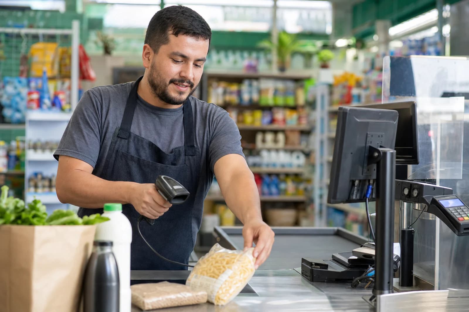 Cajero registrando productos en la caja de un comercio